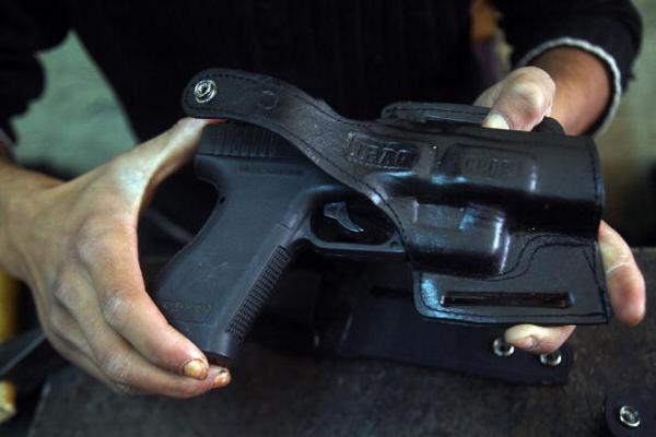 An Iraqi man tests a gun holster made at